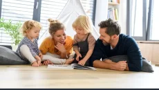 A family looking at a family tree in a book, and wonderin