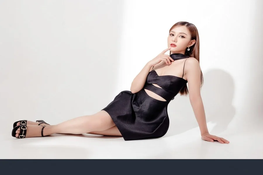 A young woman posing for a photo in an all black hoco fit.